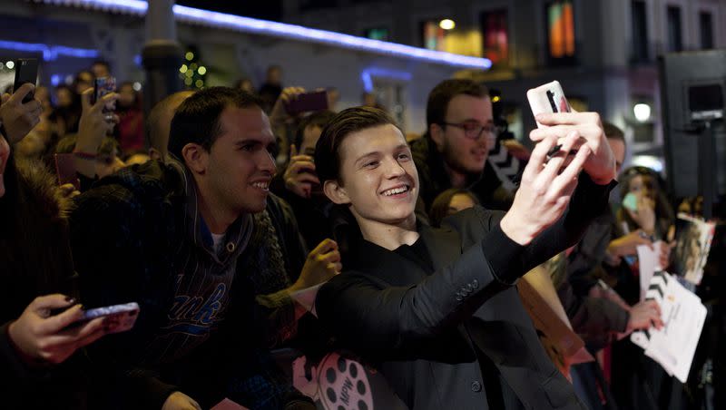 British actor Tom Holland takes a selfie with spectators during the premiere of the film: “In the Heart of the Sea,” in Madrid, Spain, on Dec. 3, 2015.