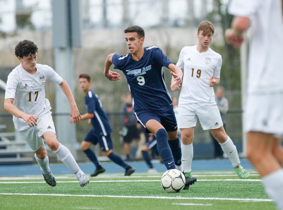 John Jay-East Fishkill midfielder Matt Rabadi dribbles between Arlington defenders during a Sept. 24, 2018, boys soccer game.