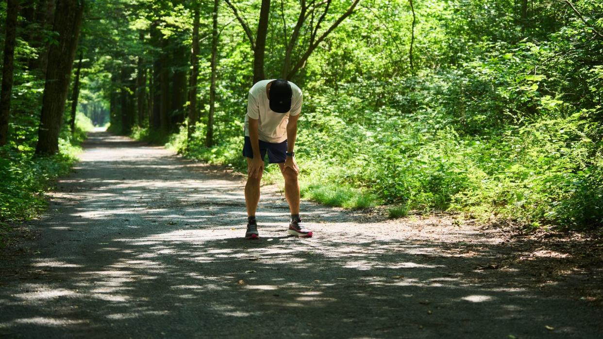 a runner with hands on his knees after a hard effort