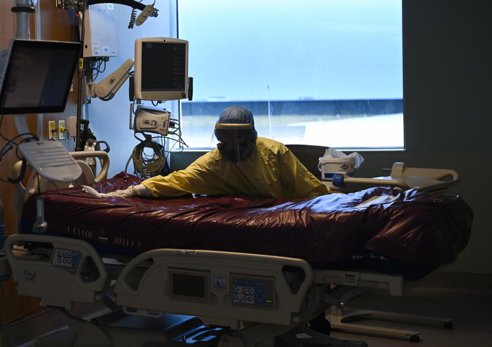 An essential worker thoroughly cleans a COVID-19 patient's room after they were transferred out of the intensive care unit at the Humber River Hospital in Toronto on Tuesday, April 13, 2021. (Nathan Denette/The Canadian Press via AP)