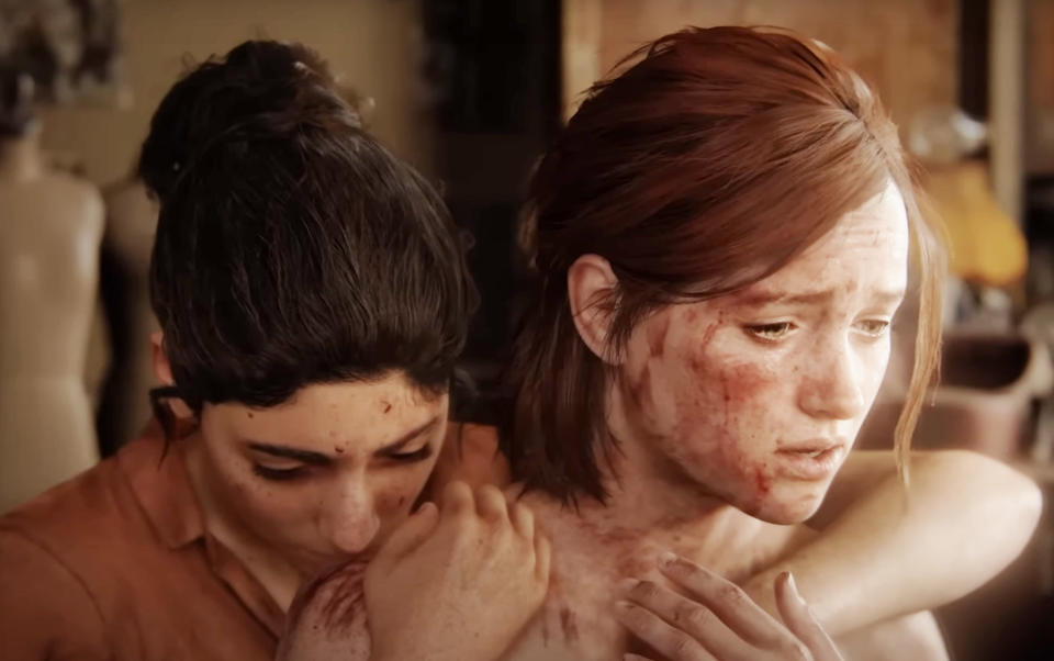 Two characters, Ellie and Dina from the video game "The Last of Us," appear distressed, embracing for comfort