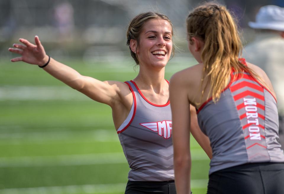 Morton's Adeline Smith, facing, goes in to hug teammate Stephanie Rosenthal after they and teammates Sophie Krueger and Taygen Beyer won the 4X800-meter relay during the Class 2A Girls Dunlap Sectional track and field meet Wednesday, May 11, 2022 at Dunlap High School.