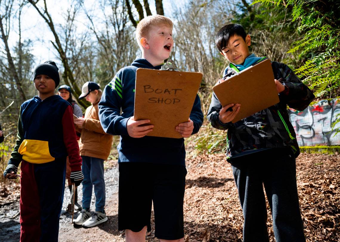 Grant Elementary School fifth graders Keller Schwartz, 11, left, and Keagan Kuapahi, 11, right, explore the woods at Swan Creek Park looking for certain species of plants during a school field trip that is part of the Foss Waterway Seaport Salmon in the Classroom program, in Tacoma on March 15, 2023.