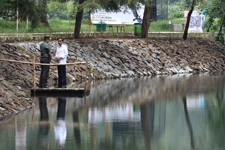 Indonesia President Joko Widodo (R) talks with the local military commander during a visit to Lake Cisanti, the source of the Citarum River, south of Bandung, West Java, Indonesia February 22, 2018 in this photo taken by Antara Foto. Antara Foto/Puspa Perwitari/via REUTERS