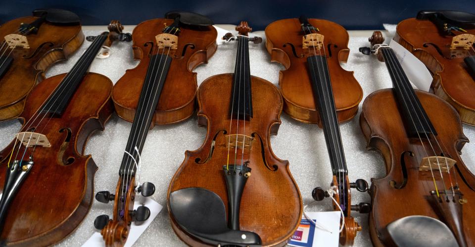 Instruments are prepared for display in the Violins of Hope exhibit Thursday, Aug. 25, 2022 at the Rhythm Discovery Center in downtown Indianapolis. The exhibit features some of the violins, violas and cellos collected and restored by Amnon and Avshalom Weinstein who collected them from Jewish survivors of the Holocaust.  In the Indianapolis show, there are 27 violins, 1 viola and 1 cello.  Also, one instrument will be played by two performers during the International Violin Competition of Indianapolis, which is running its 11th Quadrennial Competition this year, in tandem with the Violins of Hope exhibit.