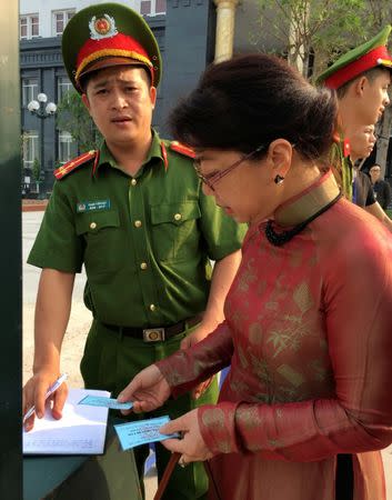 Policemen stop and check a pass of Le Thi Minh Ha, wife of Vietnamese prominent blogger Anh Ba Sam whose real name is Nguyen Huu Vinh, before his appeal trial and of Vinh's assistant Nguyen Thi Minh Thuy in Hanoi, Vietnam September 22, 2016. REUTERS/Nguyen Tien Thinh