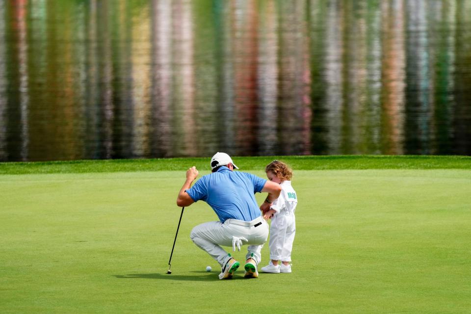 Rory McIlroy squats down to talk to his daughter, Poppy, 2, during the 2023 Masters Par 3 Contest at the Augusta National Golf Club. McIlroy, who has never won the Masters, is skipping this year's Par 3 Contest.
