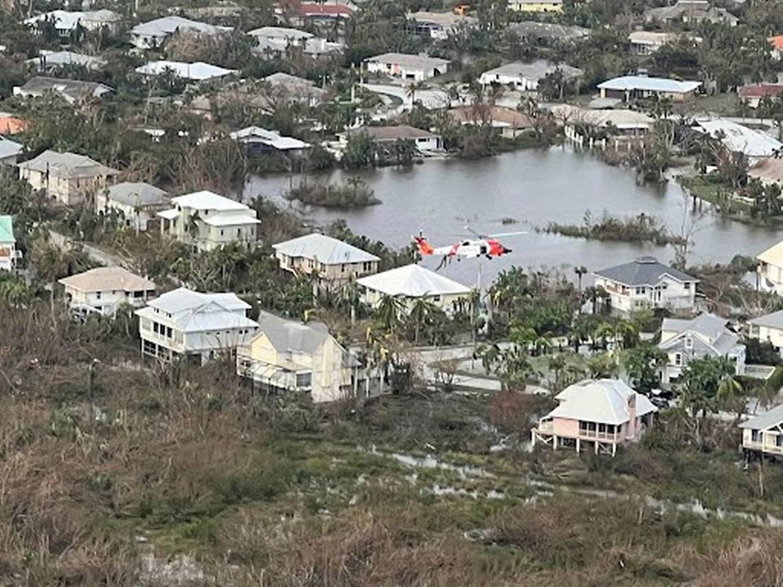 A U.S. Coast Guard aircrew hoists people from flooded areas near Sanibel, Florida, after Hurricane Ian, Sept. 29, 2022. Crews continue to conduct search and rescue operations in affected areas.