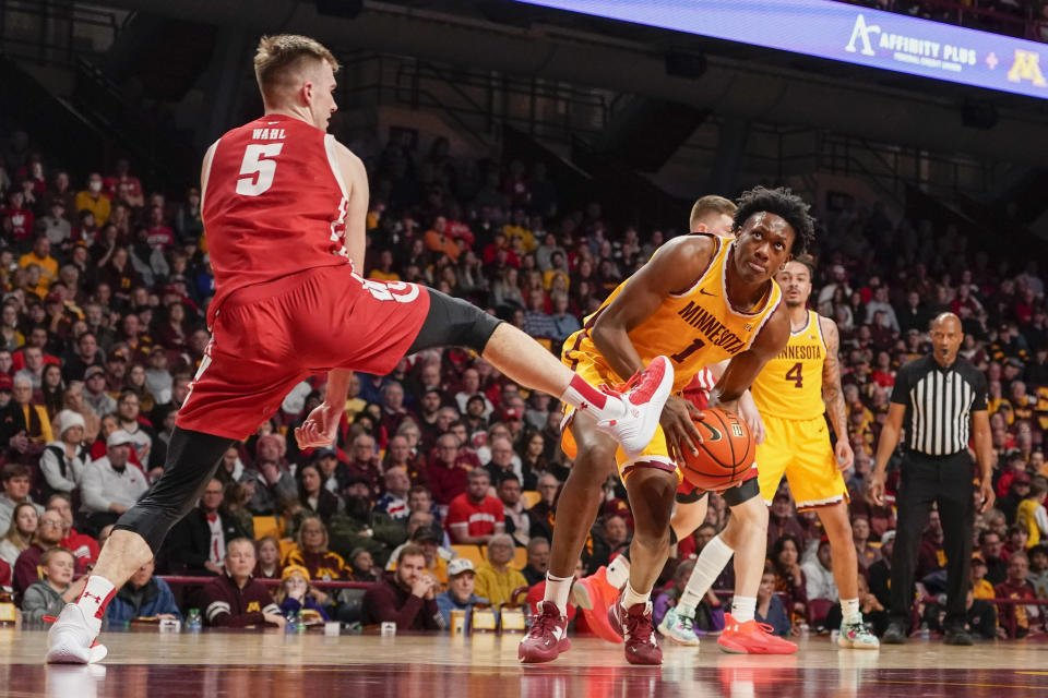 Minnesota forward Joshua Ola-Joseph (1) looks to shoot past Wisconsin forward Tyler Wahl (5) during the first half of an NCAA college basketball game on Sunday, March 5, 2023, in Minneapolis. (AP Photo/Craig Lassig)