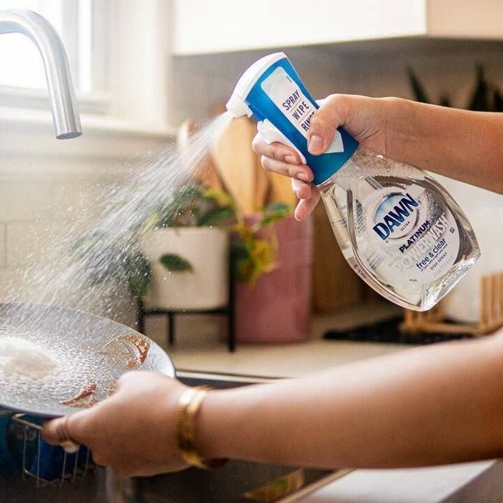 someone spraying the dish soap on a dish