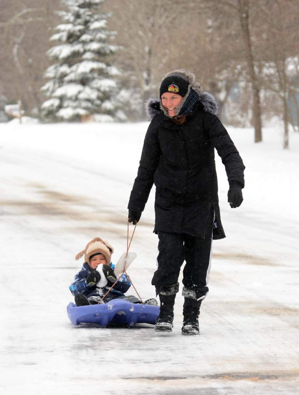Nicole LeBlanc of Colchester pulls her son, Ryan, 2, in a sled after a snowstorm in Colchester. She said of the snow, "We love it. I love the winter more than the summer."