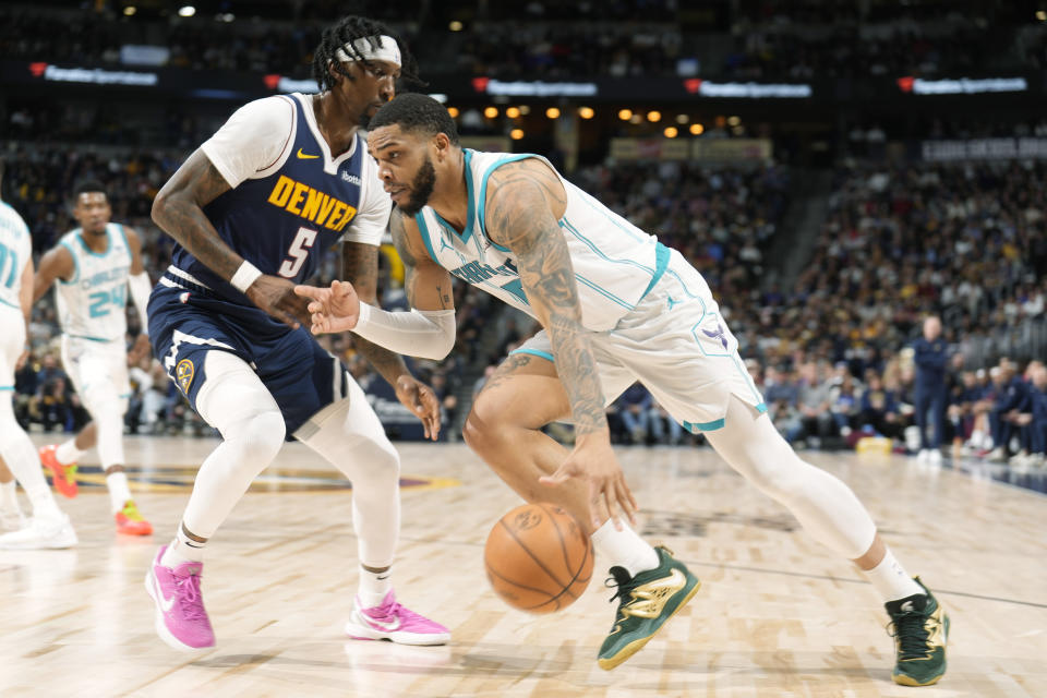 Charlotte Hornets forward Miles Bridges, front, drives to the rim as Denver Nuggets guard Kentavious Caldwell-Pope (5) defends in the second half of an NBA basketball game Monday, Jan. 1, 2024, in Denver. (AP Photo/David Zalubowski)