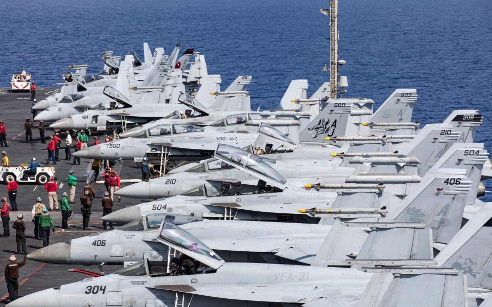 F/A-18 Super Hornet fighter jets on the deck of a US Navy aircraft carrier.  The F/A-18 may be able to carry the powerful SM-6 missile, previously deployed in the vertical launch cells of warships