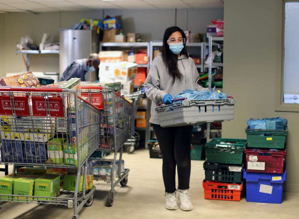 A volunteer wearing protective personal equipment (PPE) organises food parcels at the Sufra NW London food bank in Neasden, which provides emergency supplies of essential food to individuals and families struggling during the lockdown. Picture date: Friday May 15, 2020
