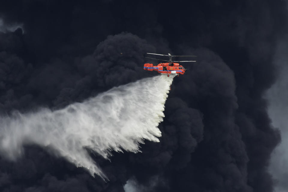 A helicopter drops a fire-retardant in a massive factory fire in Samut Prakan province, Thailand, Monday, July 5, 2021. A massive explosion at a factory on the outskirts of Bangkok has shaken an airport terminal serving Thailand’s capital, damaged homes in the surrounding neighborhood, and prompted the evacuation of a wide area over fears of poisonous fumes from burning chemicals and the possibility of additional denotations. (AP Photo/Chatchaphat Thongkorn)