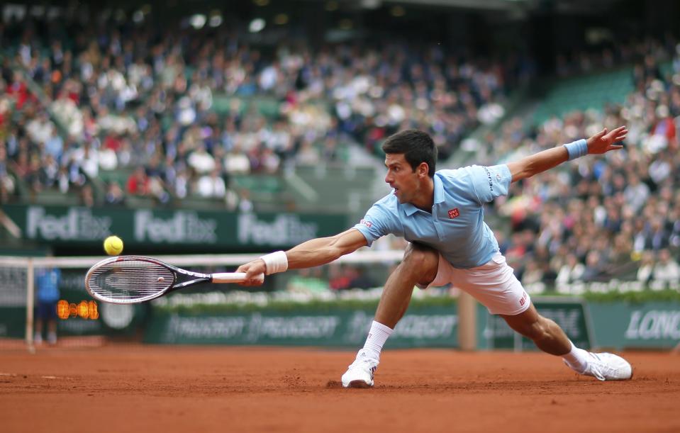 Novak Djokovic of Serbia hits a return to Joao Sousa of Portugal during their men's singles match at the French Open tennis tournament at the Roland Garros stadium in Paris May 26, 2014. REUTERS/Gonzalo Fuentes (FRANCE - Tags: SPORT TENNIS TPX IMAGES OF THE DAY)