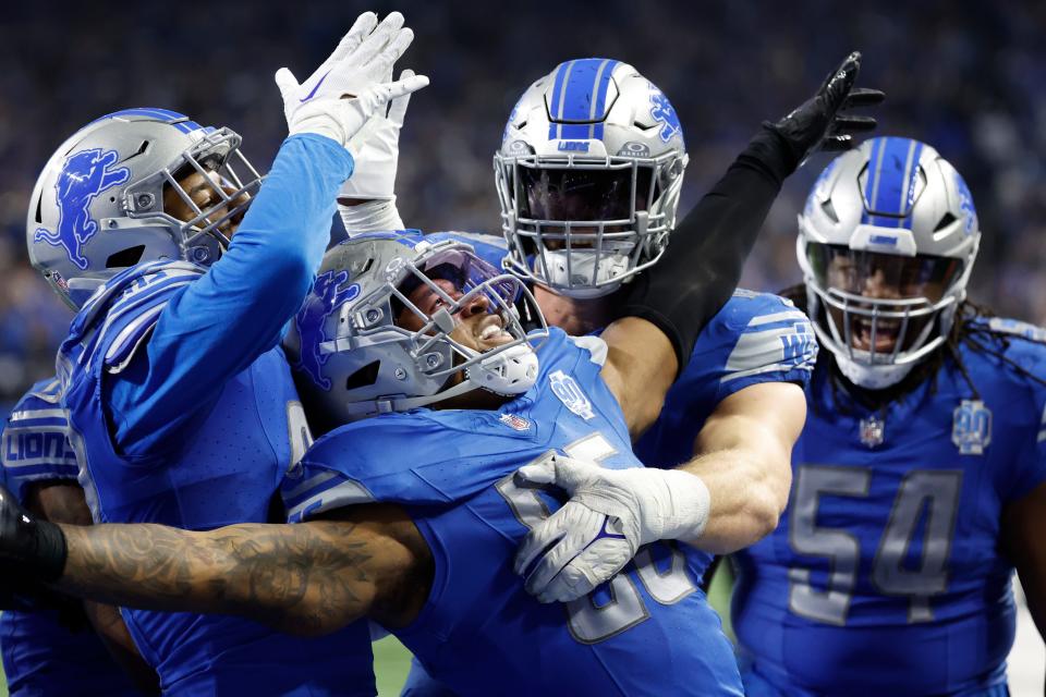 Detroit Lions linebacker Derrick Barnes (55) receives congratulations from defensive lineman John Cominsky, who's to Barnes' immediate left, and other teammates after his game-clinching interception against the Tampa Bay Buccaneers on Sunday.