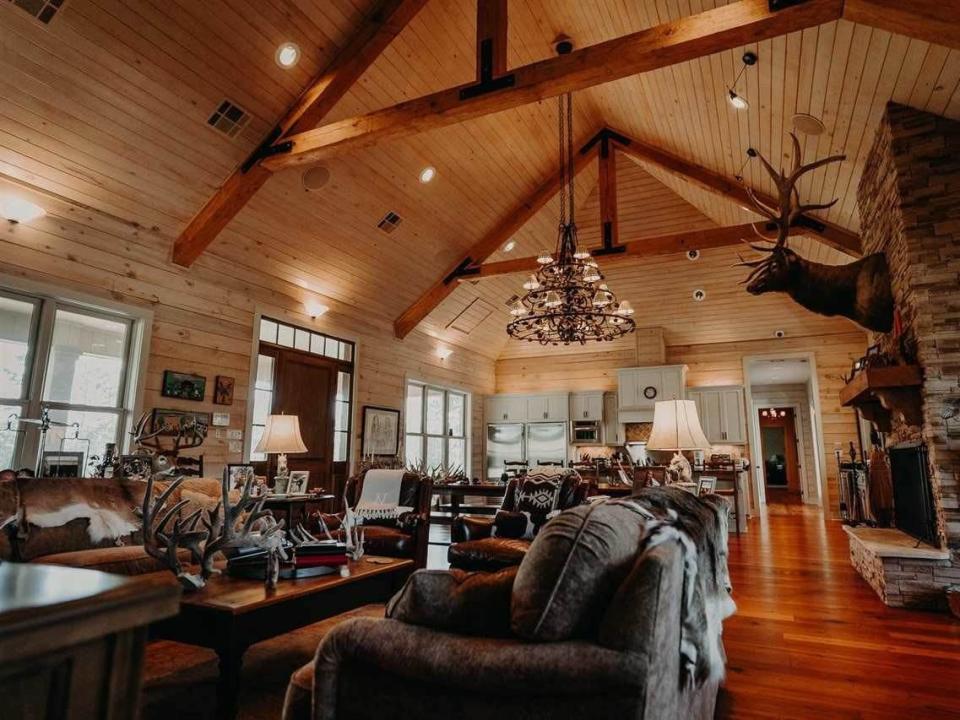 Living room with mounted deer head and wooden ceiling in Mississippi