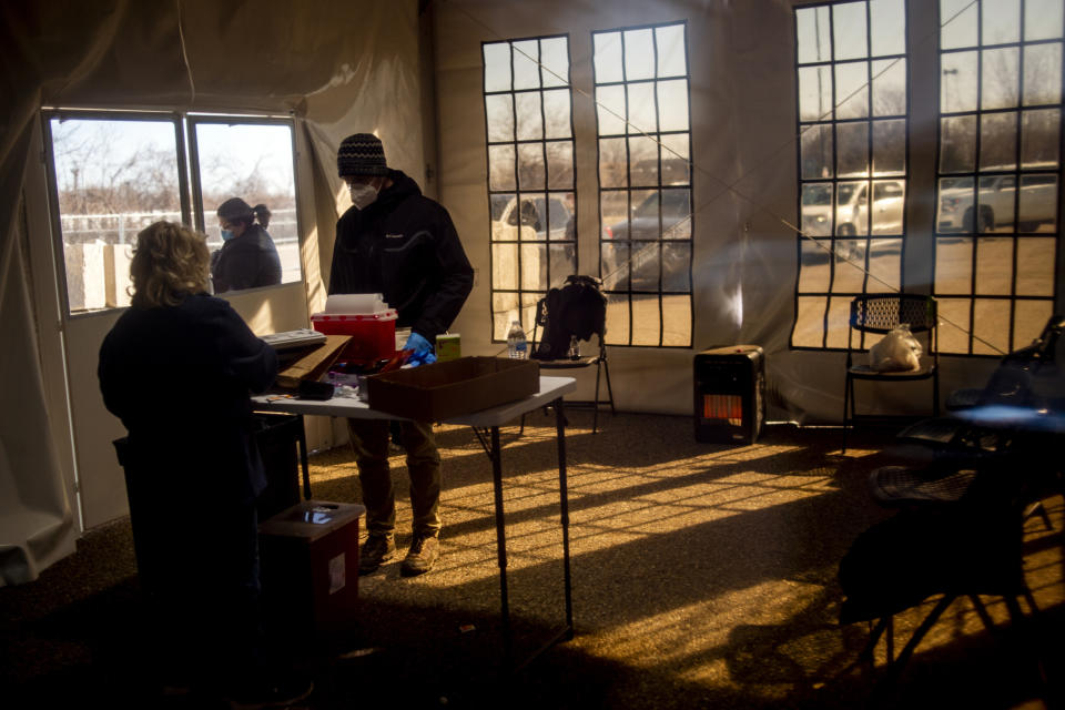 FILE - In this March 29, 2021, file photo, Joshua Severeide, a UM-Flint nursing student, prepares to give some of the hundreds of first doses of the Moderna COVID-19 vaccine to Genesee County residents at Bishop Airport in Flint, Mich. The Genesee County Health Department continues to facilitate the vaccination of local residents. (Jake May/The Flint Journal via AP, File)