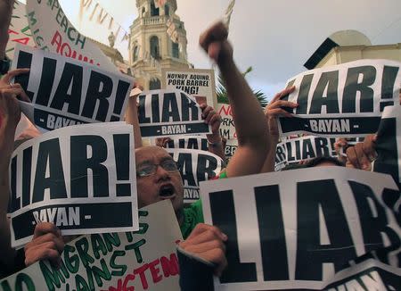 A protestor clenches his fist as he shouts anti-government slogans after watching Philippine President Benigno Aquino address the nation in a live television broadcast, in front of the Catholic church in Quiapo, metro Manila July 14, 2014. REUTERS/Romeo Ranoco