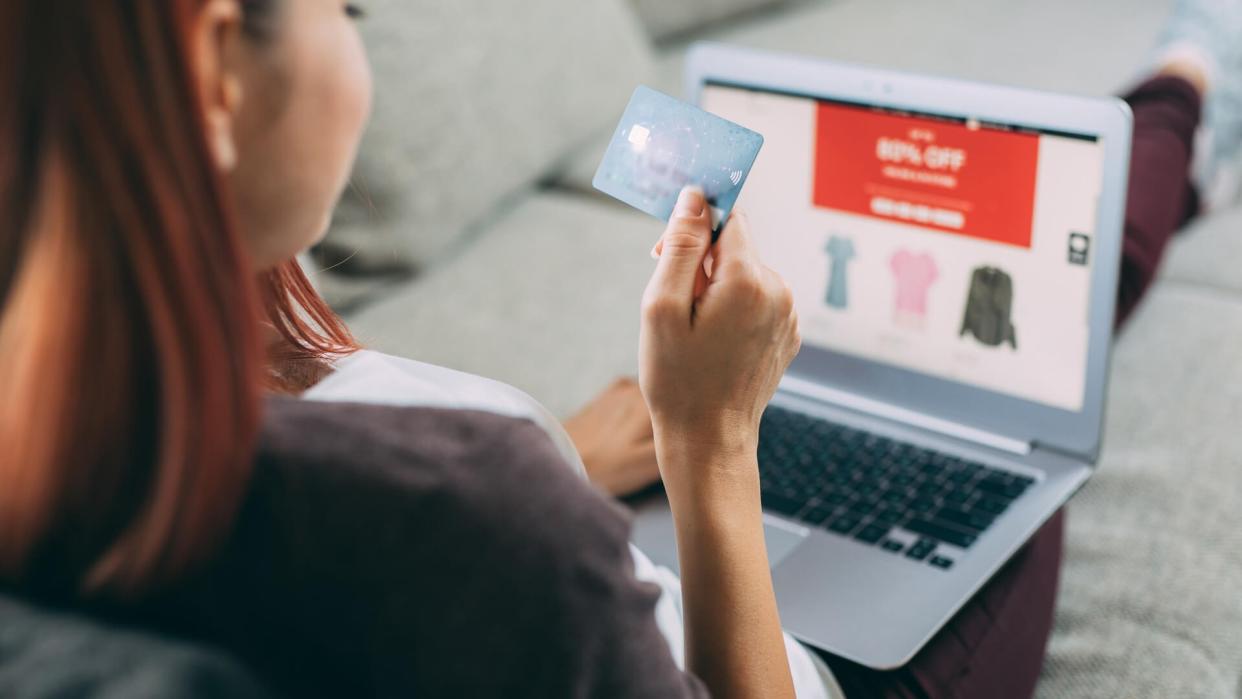 Woman making online payment via laptop at home.