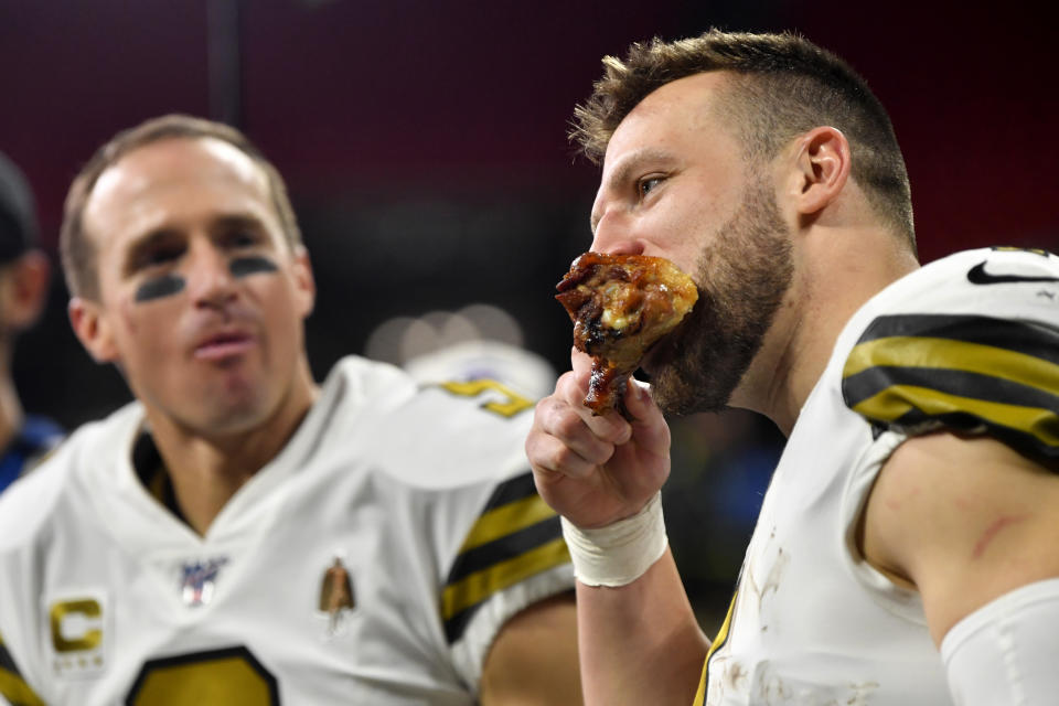 New Orleans Saints quarterback Taysom Hill, right, eats a drumstick after an NFL football game against the Atlanta Falcons, Thursday, Nov. 28, 2019, in Atlanta. The New Orleans Saints won 26-18. (AP Photo/John Amis)