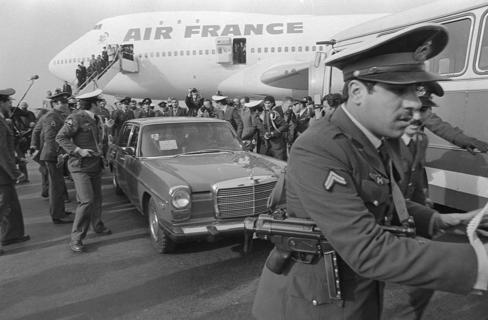 FILE - In this Feb. 1, 1979 file photo, Ayatollah Ruhollah Khomeini has a heavy escort as he enters car to leave the airport in Tehran, Iran. Friday, Feb. 1, 2019, marks the 40th anniversary of Khomeini's descent from the chartered Air France Boeing 747, a moment that changed the country’s history for decades to come. (AP Photo/FY, File)