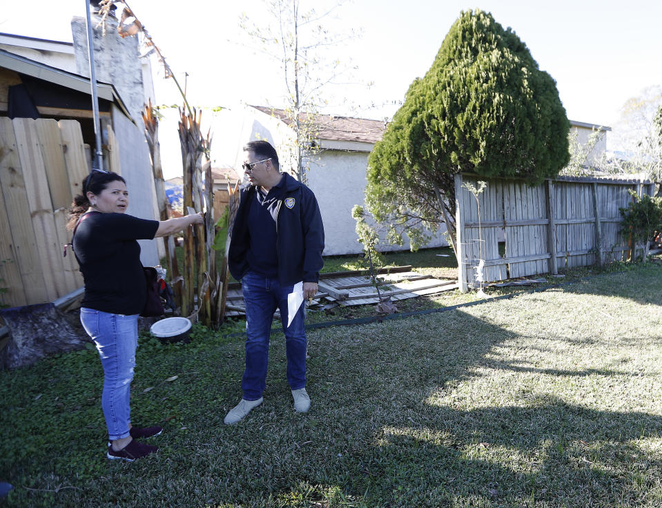 Houston Fire Chief Samuel Peña talks with Hortensia Lima, whose home was seriously damaged and deemed uninhabitable on Stanford Court in Houston, Sunday, Jan. 26, 2020, after the Friday morning explosion at the Watson Grinding Manufacturing plant. (Karen Warren/Houston Chronicle via AP)