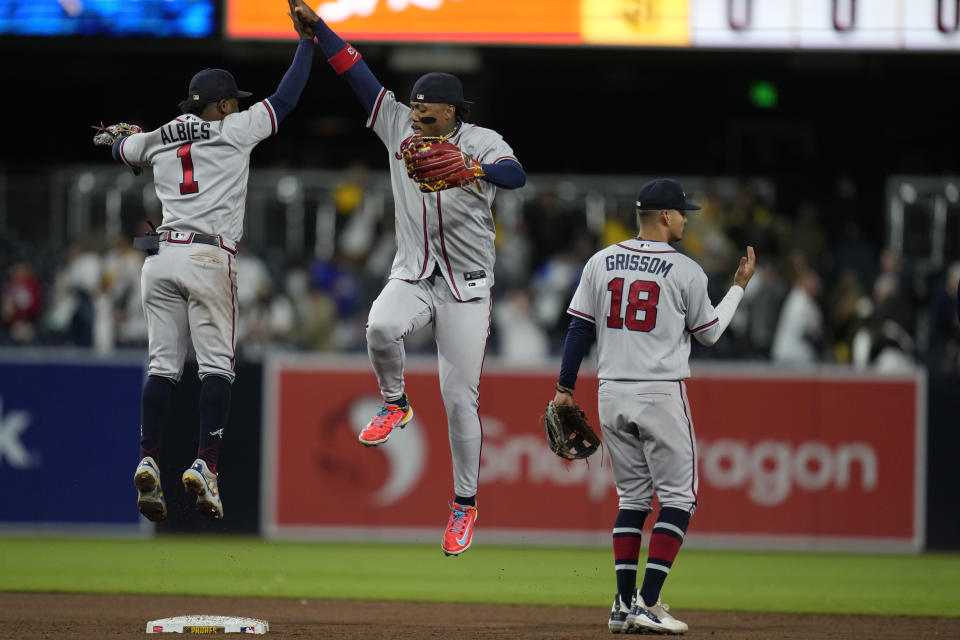 Atlanta Braves second baseman Ozzie Albies (1) celebrates with teammates right fielder Ronald Acuna Jr., center, and shortstop Vaughn Grissom after the Braves defeated the San Diego Padres 8-1 in a baseball game Tuesday, April 18, 2023, in San Diego. (AP Photo/Gregory Bull)