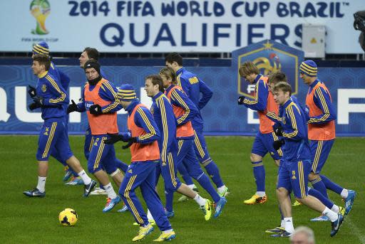 Jugadores de la selección de fútbol de Ucrania trotan durante una práctica el 18 de noviembre de 2013, la víspera del duelo de vuelta de repesca europea al Mundial-2014, ante Ucrania, en el estadio Saint-Denis, periferia de París. (AFP | Franck Fife)