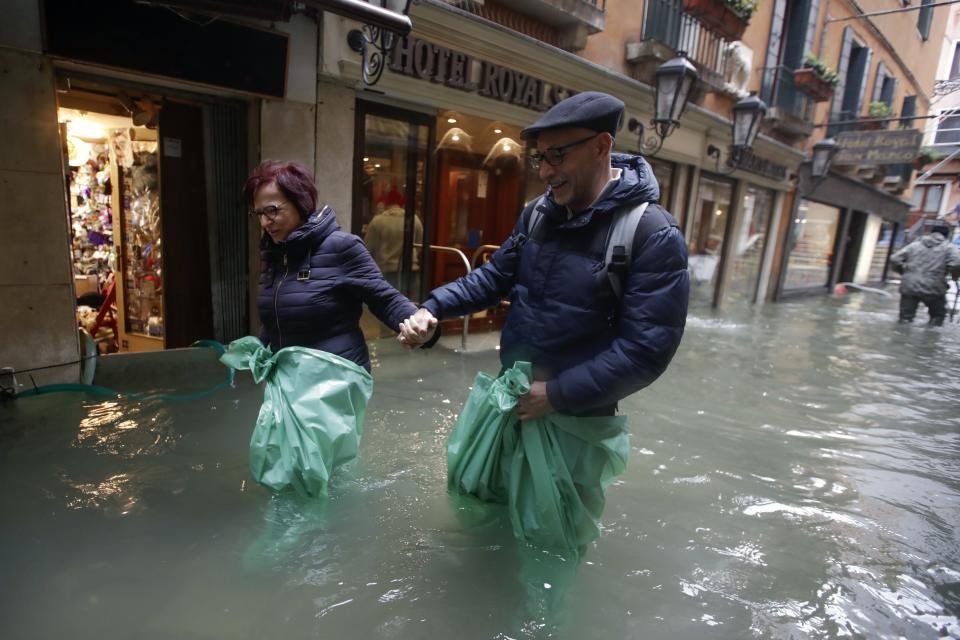 A couple wades their way through water in Venice, Italy, on Nov. 15, 2019.&nbsp; (Photo: ASSOCIATED PRESS)
