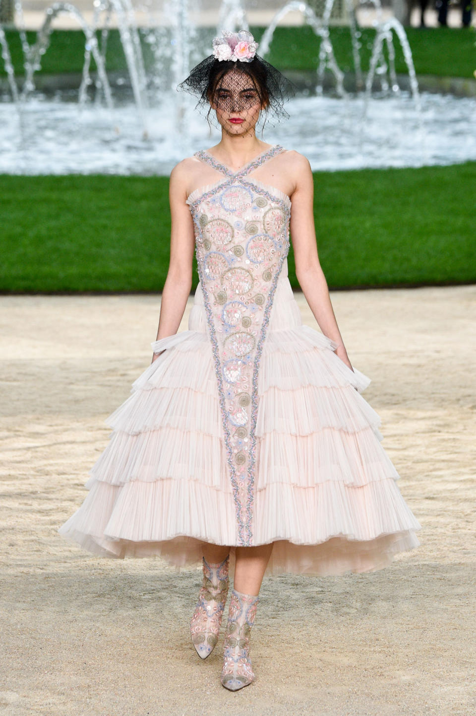 <p>Model wears a blush pink pleated halter dress with colored crystal embellishments from the Chanel SS18 Haute Couture show. (Photo: Getty Images) </p>