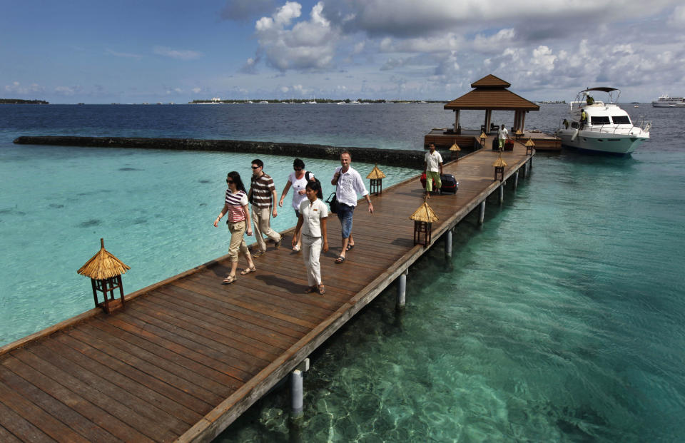 FILE- Foreign tourists arrive in a resort in the Kurumba island in Maldives, Feb. 12, 2012. Relationship between India and the Maldives is facing challenges after officials in the tiny island nation made derogatory remarks against Prime Minister Narendra Modi’s posts that promoted the pristine beaches of India’s Lakshadweep archipelago. (AP Photo/ Gemunu Amarasinghe, File)