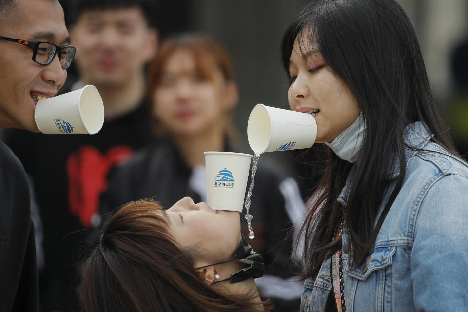 People play games as they gather for a barbecue at a scenic area in Fangshan district in Beijing, Monday, May 4, 2020, after authorities loosened up nationwide restrictions following months of lockdown over the coronavirus outbreak. (AP Photo/Andy Wong)