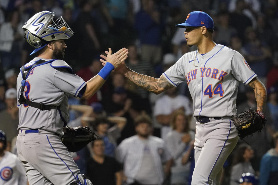New York Mets catcher Tomas Nido, left, celebrates with relief pitcher Yoan Lopez after the Mets defeated the Chicago Cubs in the second baseball game of a doubleheader in Chicago, Saturday, July 16, 2022. (AP Photo/Nam Y. Huh)