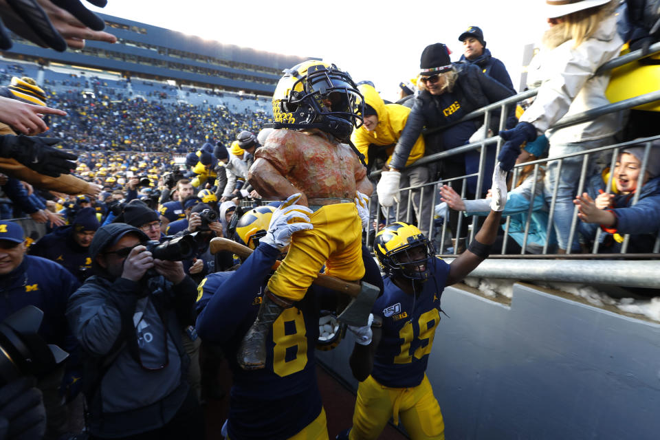 Michigan linebacker Devin Gil (8) carries the Paul Bunyan Trophy after beating Michigan State 44-10 in an NCAA college football game in Ann Arbor, Mich., Saturday, Nov. 16, 2019. (AP Photo/Paul Sancya)