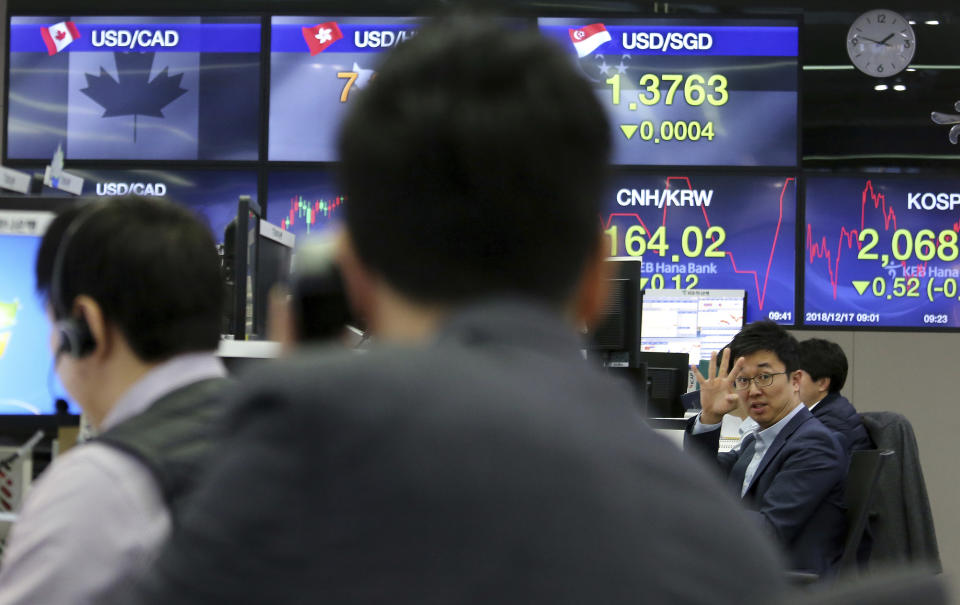 A currency trader gestures at the foreign exchange dealing room of the KEB Hana Bank headquarters in Seoul, South Korea, Monday, Dec. 17, 2018. Asian markets rose Monday on hopes that the Federal Reserve would re-evaluate its hawkish stance at a meeting later this week, following signs of slower global growth. (AP Photo/Ahn Young-joon)