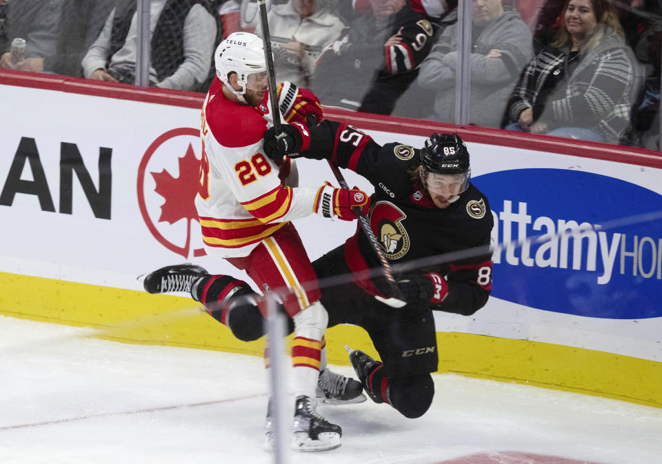 Calgary Flames center Elias Lindholm collides with Ottawa Senators defenseman Jake Sanderson during the third period of an NHL hockey game, Saturday, Nov. 11, 2023 in Ottawa, Ontario. (Adrian Wyld/The Canadian Press via AP)