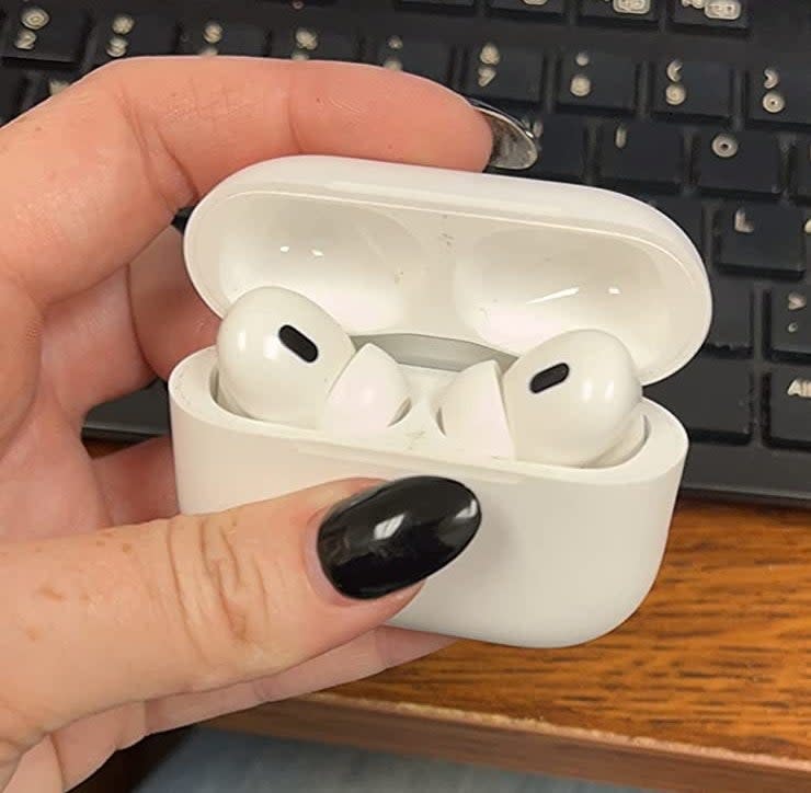 reviewer holding the AirPods