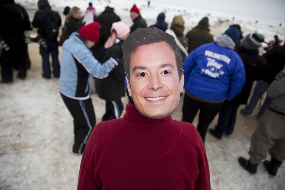 Kay Golden, of Chicago, wears a Jimmy Fallon mask on the back of her head while waiting for the start of the Chicago Polar Plunge on Sunday, March 2, 2014, in Chicago. Chicago Mayor Rahm Emanuel and "The Tonight Show" host Jimmy Fallon entered the water during the event. (AP Photo/Andrew A. Nelles)