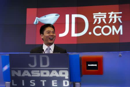 Richard Liu (C), CEO and founder of China's e-commerce company JD.com, smiles before ringing the opening bell at the NASDAQ Market Site building at Times Square in New York May 22, 2014. REUTERS/Shannon Stapleton