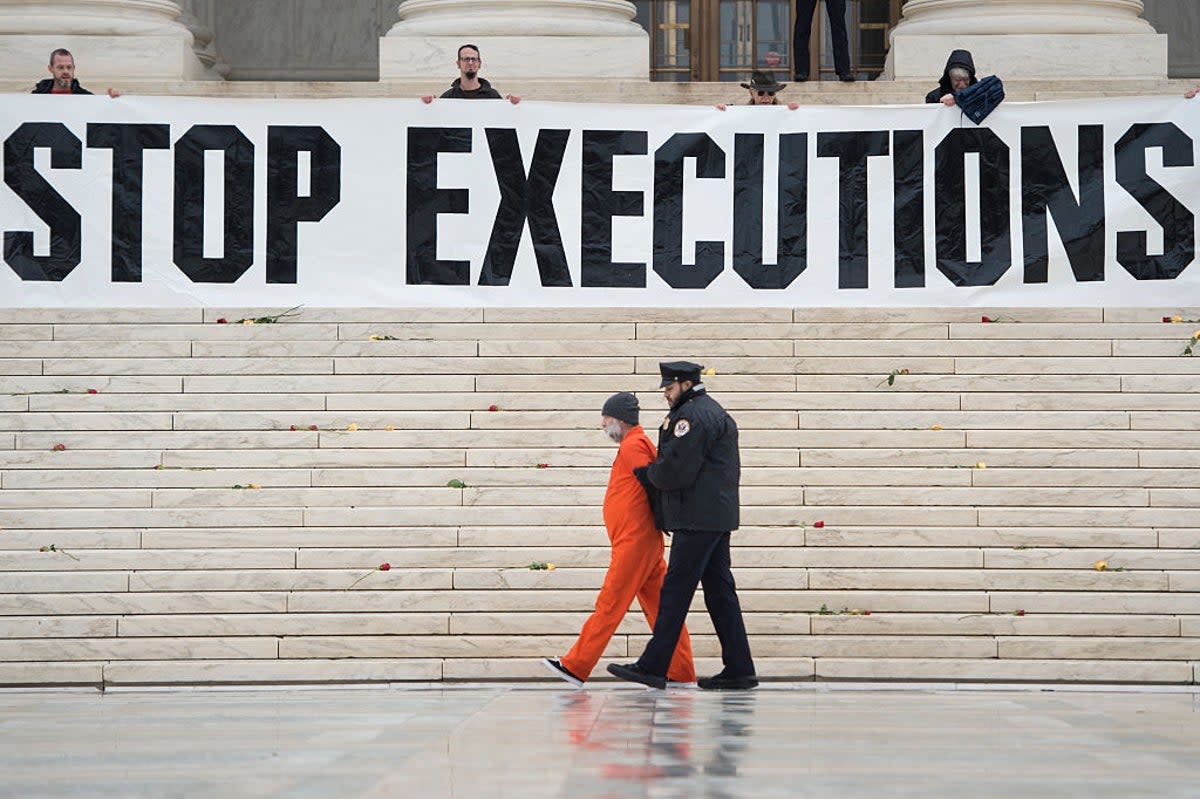 Randy Gardner is removed by police while wearing his executed brother's prison jumpsuit during a protest against the death penalty at the US Supreme Court (AFP via Getty)