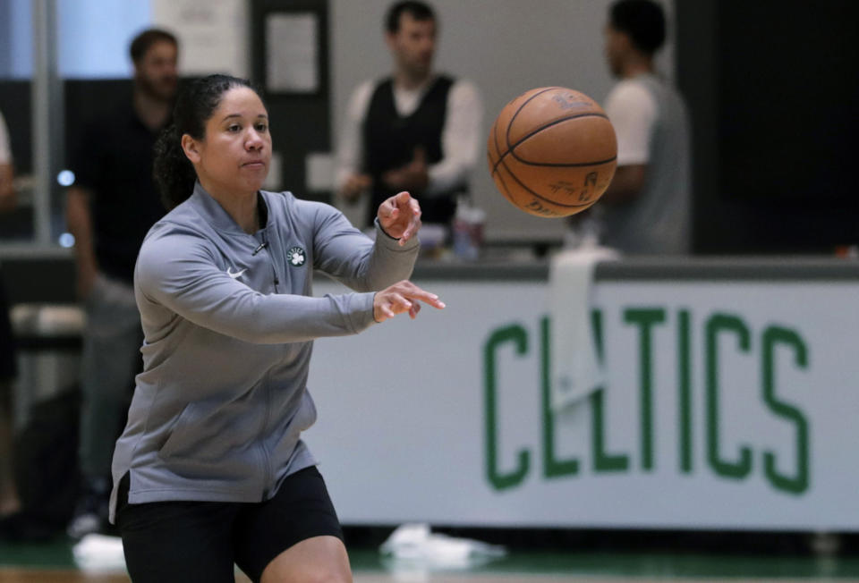 FILE - In this July 1, 2019, file photo, Boston Celtics assistant coach Kara Lawson passes the ball at the team's training facility in Boston. Celtics guard Gordon Hayward said Lawson has already made her presence felt. “She’s been good as far as just the experience she has as a basketball player,” Hayward said. “Reading the game and kind of little things she sees coaching on the sideline. Having somebody that well-versed in basketball, that experience is good.” (AP Photo/Charles Krupa, File)