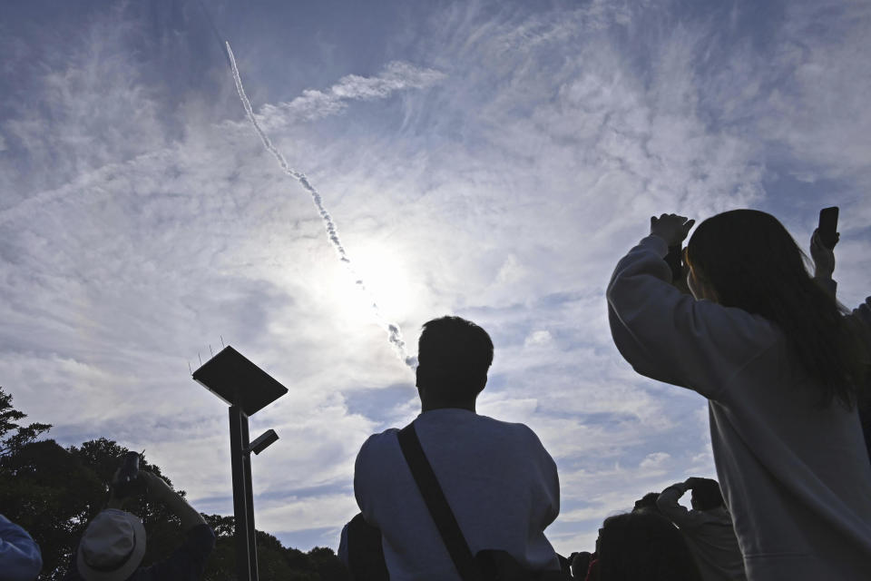 People in Minamitane town, Kagoshima, southern Japan, watch as an H3 rocket lifts off from Tanegashima Space Center Saturday, Feb. 17, 2024. (Kyodo News via AP)