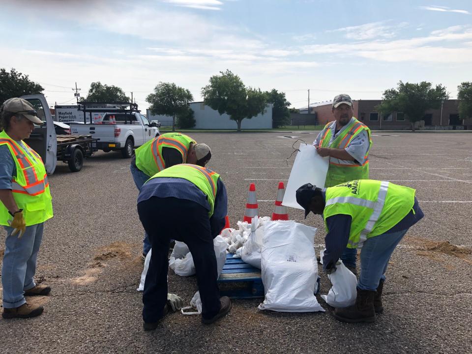City of Amarillo employees hand out bags of sand to flood victims Tuesday. They started early in the morning and ran out of supplies quickly, but said more was coming from the Army Corps of Engineers in Canyon.