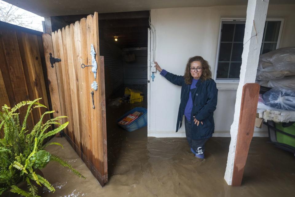 Teresa Fuentes becomes emotional after seeing flood damage to belongings at her home on College Road in Watsonville, Calif.