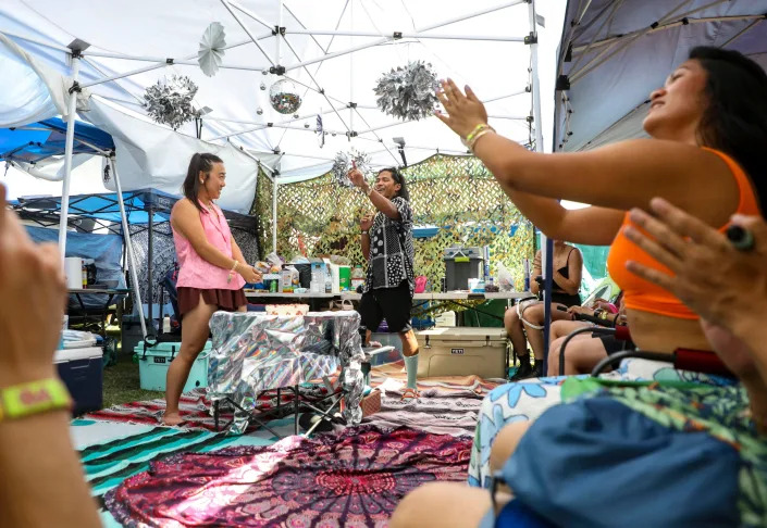 Jeronie Alcantara says a few words about his wife,Lily, before the couple cuts a cake in their campsite just a few days after being married before the Coachella Valley Music and Arts Festival in Indio, Calif., Sunday, April 17, 2022.