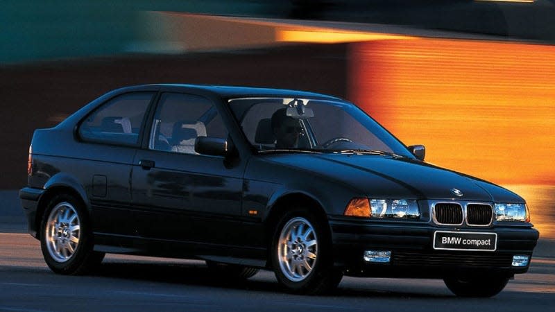 A photo of a BMW E36 driving on a road. 