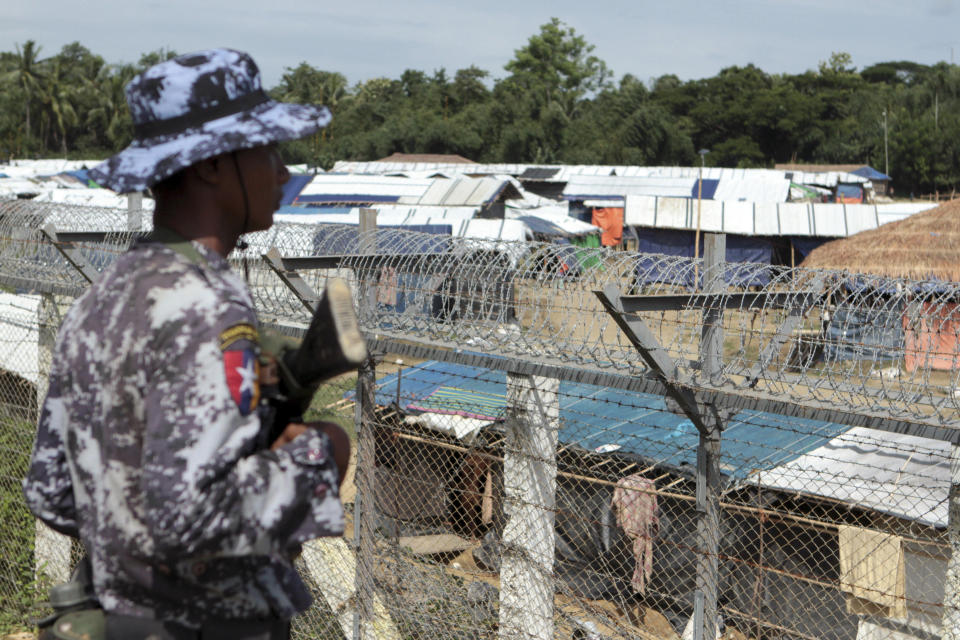 FILE - In this June 29, 2018, file photo, a Myanmar border guard stands to provide security near a fence at a no-man's land between Myanmar and Bangladesh, near Taungpyolatyar village, Maung Daw, northern Rakhine State, Myanmar. The U.N. Human Rights Council said in a statement on Tuesday, May 14, 2019 that there has been no progress in the crisis over Myanmar’s mostly Muslim Rohingya minority, more than 1 million of whom have fled military “clearance operations” in the northwest Rakhine region. It said those remaining in the country live in displacement camps and in fear. (AP Photo/Min Kyi Thein, File)
