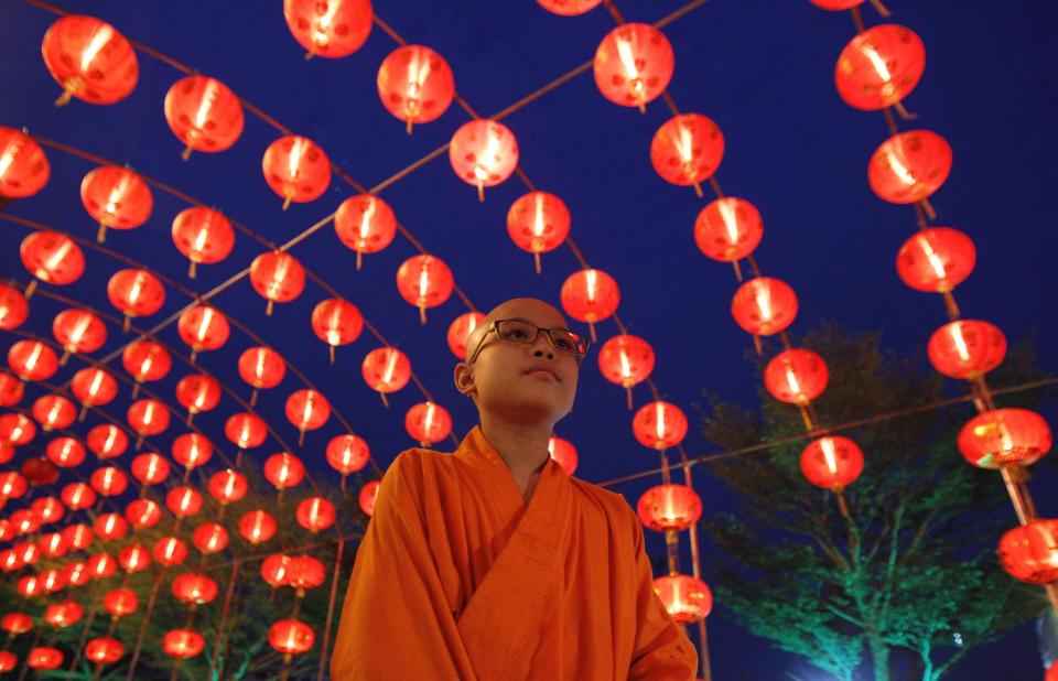 A Chinese Buddhist monk walks under decorations at a temple, ahead of the Chinese Lunar New Year celebrations in Nonthaburi province, on the outskirts of Bangkok February 18, 2015. The Chinese Lunar New Year on February 19 will welcome the Year of the Sheep (also known as the Year of the Goat or Ram). (REUTERS/Chaiwat Subprasom)